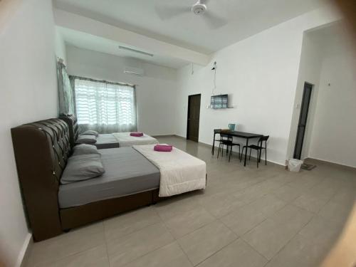 a bedroom with a bed and a table in it at Roomstay Gemilang in Kuala Terengganu