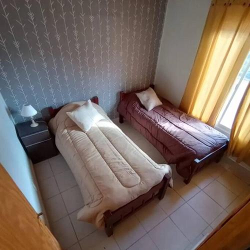 a bedroom with a bed and a couch and a window at Cumbreluz, Potrerillos in Potrerillos