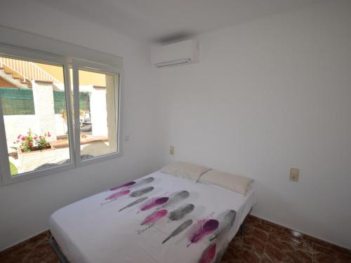 a bedroom with a bed with purple flowers on it at Casa Sant Miquel de Fluvià, 4 dormitorios, 10 personas - ES-89-91 in San Miguel de Fluviá