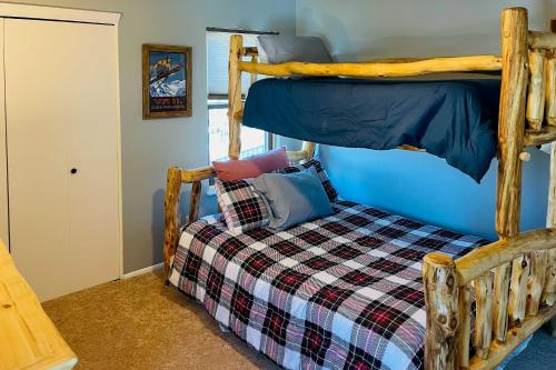 - une chambre avec des lits superposés et un couvre-lit en damier dans l'établissement Sunlight Mountain Home with Hot Tub and View!, à Carbondale