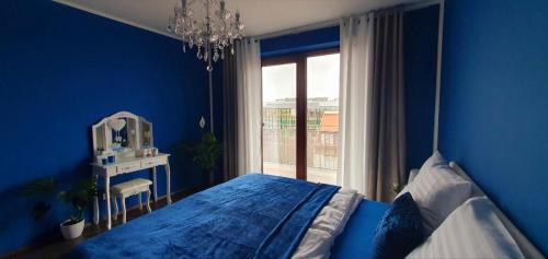 niebieska sypialnia z łóżkiem i oknem w obiekcie Apartmán Jako doma w Ołomuńcu