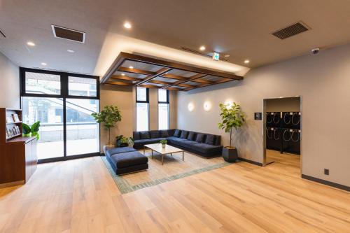 a living room with a couch and a table at Sotetsu Fresa Inn Sapporo-Susukino in Sapporo