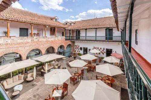 an outdoor patio with tables and chairs and umbrellas at Casa Andina Premium Cusco in Cusco