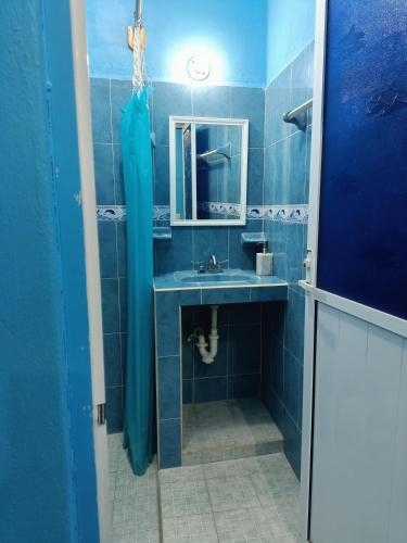 a blue bathroom with a sink and a mirror at Casa Bonzay in Bacalar