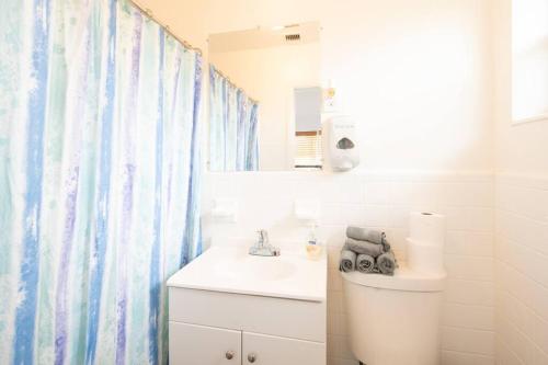 een badkamer met een wastafel, een toilet en een spiegel bij Modern 5 Bedroom Miami Home 15 Min to the Beach in Miami