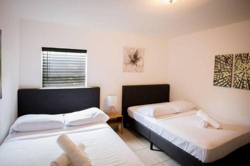 a bedroom with two beds and a window at 3 Bedroom Miami Home 15 Minutes to the Beach in Miami