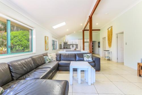 a living room with a leather couch and a table at Ocean View Apartments by Kingscliff Accommodation in Kingscliff