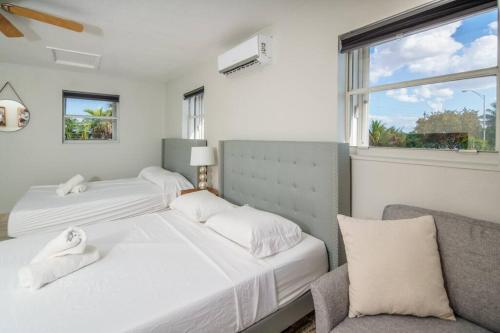 1 Schlafzimmer mit 2 Betten, einem Stuhl und einem Fenster in der Unterkunft Beautiful 7-Bedroom Villa with Pool in Hialeah