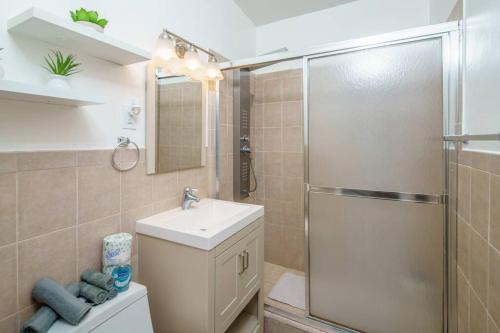 uma casa de banho com um chuveiro, um lavatório e um WC. em Beautiful 7-Bedroom Villa with Pool em Hialeah