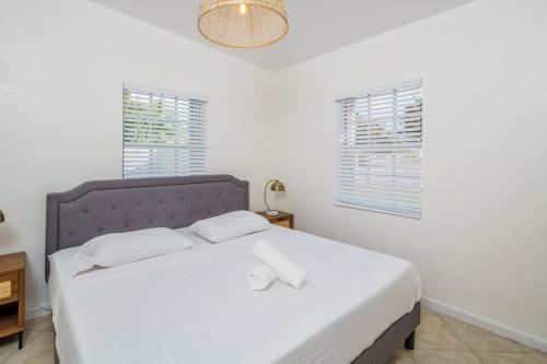 a bedroom with a large white bed with two pillows at Beautiful 7-Bedroom Villa with Pool in Hialeah