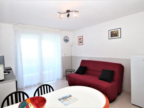 un salon avec un canapé rouge et une table dans l'établissement BANYULS-SUR-MER, T2 avec WIFI, terrasse et parking - FR-1-309-259, à Banyuls-sur-Mer