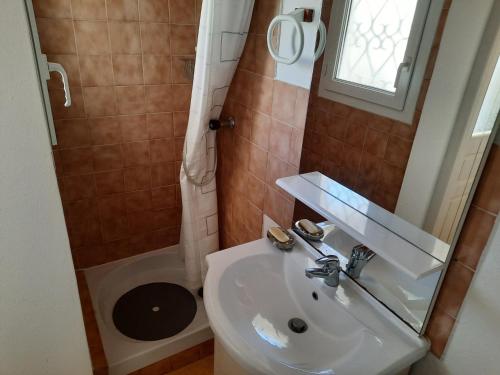 a bathroom with a sink and a toilet and a mirror at Charmant T2 avec jardin privé, proche centre et plages de Capbreton - FR-1-239-632 in Capbreton