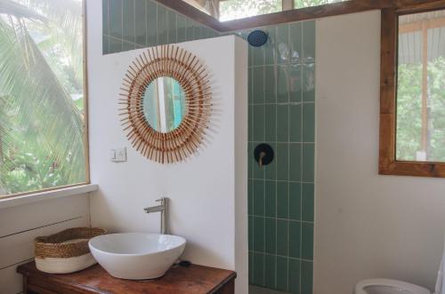 La salle de bains est pourvue d'un lavabo et d'un miroir. dans l'établissement Casa BOHÖ, à Puerto Viejo