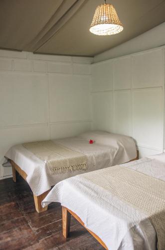 a room with two beds and a chandelier at Casa BOHÖ in Puerto Viejo