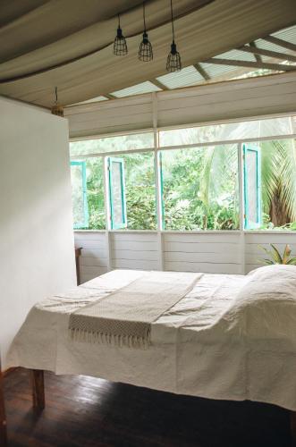a bedroom with a large bed in front of a window at Casa BOHÖ in Puerto Viejo