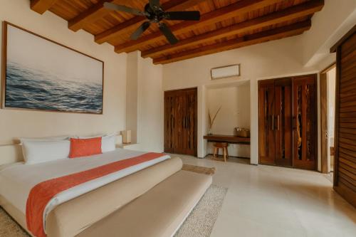 sypialnia z łóżkiem i wentylatorem sufitowym w obiekcie Las Palmas Luxury Villas w mieście Zihuatanejo