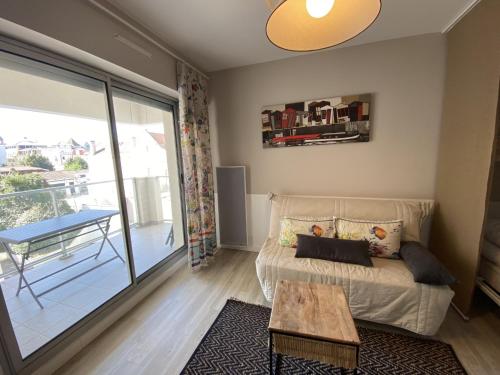 un salon avec un canapé et une table dans l'établissement Studio neuf en front de mer avec terrasse et parking, idéal pour 3 personnes - FR-1-474-147, à Arcachon