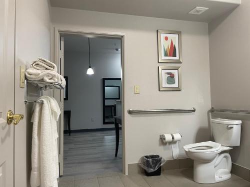 a bathroom with a toilet and a door with towels at Country Inn & Suites by Radisson, College Station, TX in College Station