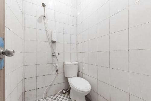 a bathroom with a toilet and a shower at Urbanview Hotel Garuda Sky Inn Balikpapan by RedDoorz in Stalkudo