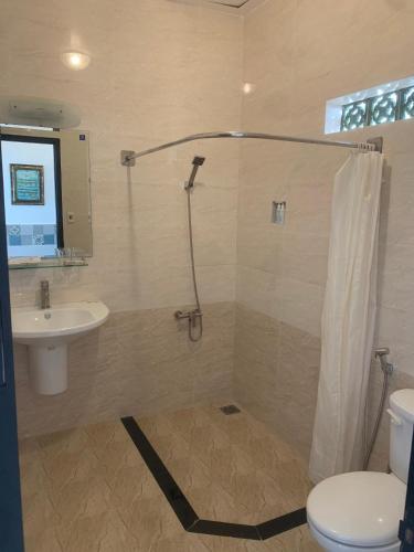 a bathroom with a shower and a toilet and a sink at DYNASTY MUINE RESORT in Ấp Thiện Phước