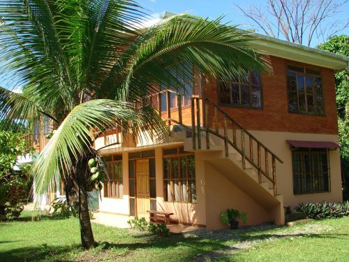 a house with a palm tree in front of it at Babilonia in Cahuita