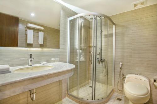 uma casa de banho com um chuveiro, um lavatório e um WC. em Sea Pearl Beach Resort & Spa Cox's Bazar em Cox's Bazar