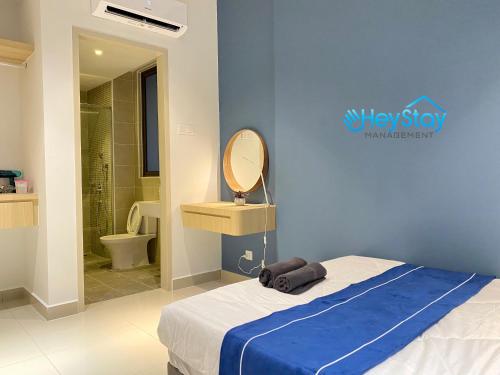 a bedroom with a bed with a blue wall at Bali Residence Melaka By Heystay Management in Melaka