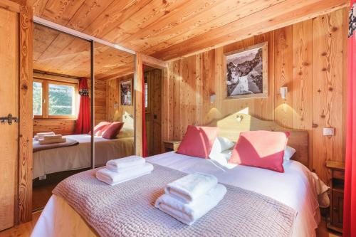 a bedroom with two beds in a log cabin at Chalet de l'Alpage - Happy Rentals in Les Houches