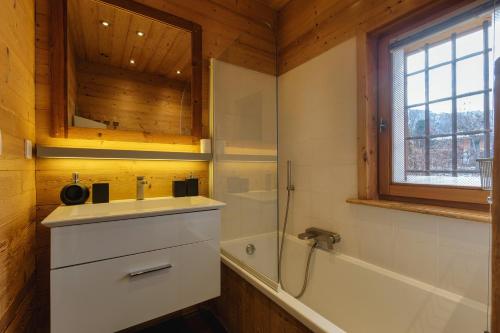 a bathroom with a sink and a shower and a tub at Chalet de l'Alpage - Happy Rentals in Les Houches