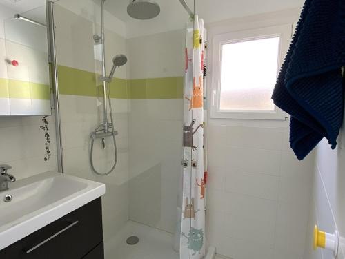 uma casa de banho com um chuveiro e um lavatório. em Maison La Bernerie-en-Retz, 3 pièces, 4 personnes - FR-1-612-17 em La Bernerie-en-Retz