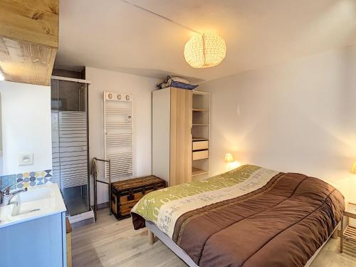 une chambre avec un lit et un lavabo dans l'établissement Charmant 2 pièces + coin cabine, proche centre Combloux, RDJ, terrasse, parking et casier à skis - FR-1-560-69, à Combloux