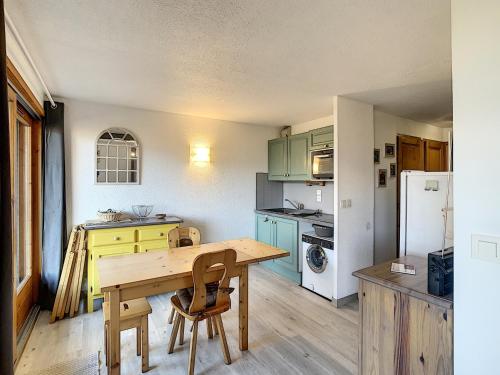 une cuisine avec une table en bois et un réfrigérateur dans l'établissement Charmant 2 pièces + coin cabine, proche centre Combloux, RDJ, terrasse, parking et casier à skis - FR-1-560-69, à Combloux