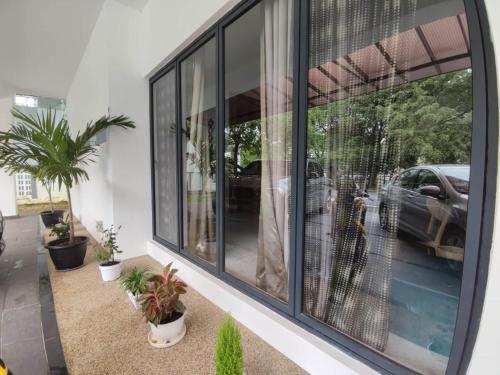 a room with windows with a car in the reflection at Bunga Raya Villa By Malvacae Homestays Shah Alam in Shah Alam