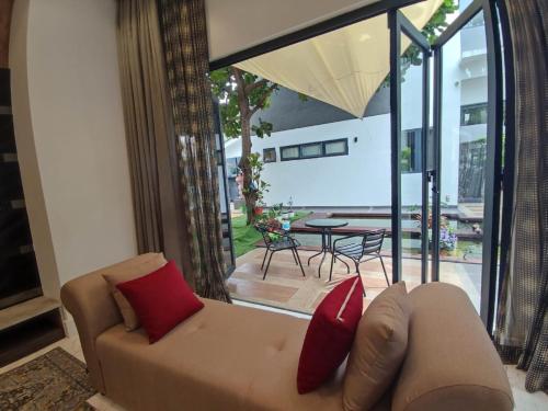 莎阿南的住宿－Bunga Raya Villa By Malvacae Homestays Shah Alam，客厅里配有红色枕头的沙发