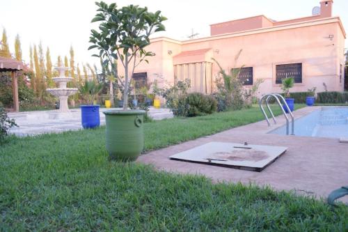 a yard with a pool and a fountain and a bucket at Villa world Marrakech in Marrakesh