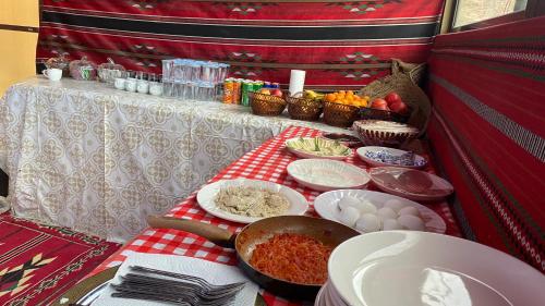 a table with food on a red and white table cloth at 7 Caves Hotel in Al Jāyah