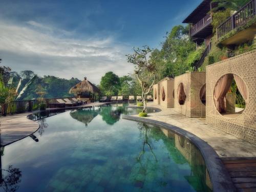 uma piscina em frente a um resort em Nandini Jungle by Hanging Gardens em Payangan