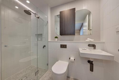 a bathroom with a toilet and a sink and a shower at Littomore Suites Kingswood in Penrith