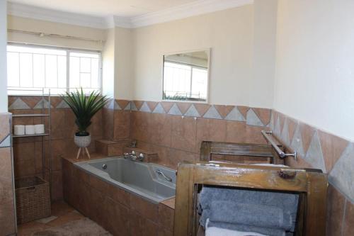 ein Badezimmer mit einer Badewanne und einem Waschbecken in der Unterkunft BlesBok House in Bronkhorstspruit