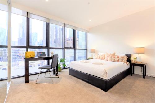 1 dormitorio con 1 cama, escritorio y ventanas en Arrow on Swanston, en Melbourne