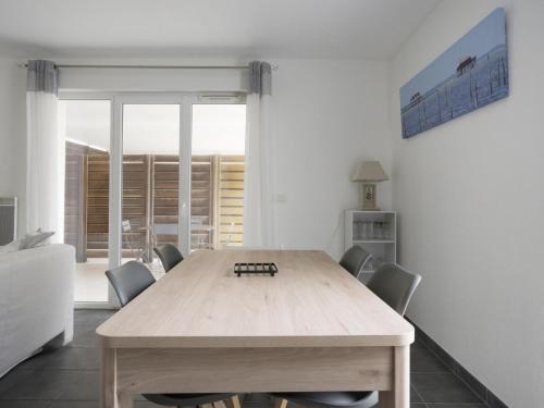 une salle à manger avec une table et des chaises en bois dans l'établissement Appartement T3 à 50m de l'océan avec terrasse, parking et Wi-Fi - Refait à neuf, centre de Biscarrosse - FR-1-521-155, à Biscarrosse
