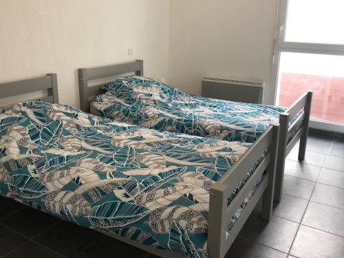 deux lits côte à côte dans une chambre dans l'établissement Appartement T3 à 50m de l'océan avec terrasse, parking et Wi-Fi - Refait à neuf, centre de Biscarrosse - FR-1-521-155, à Biscarrosse