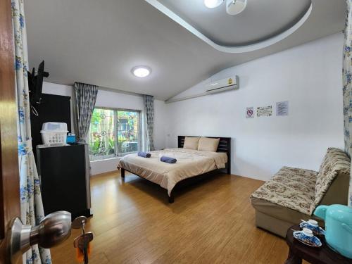 1 dormitorio con 1 cama y 1 sofá en una habitación en Kao Ngu Boutique Resort, en Ban Rong Chang
