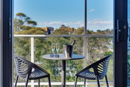 a table and two chairs in front of a window at Littomore Suites Kingswood in Penrith