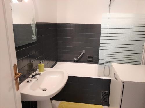 ein Badezimmer mit einem Waschbecken und einer Badewanne in der Unterkunft Appartement Saint-Jean-de-Luz, 4 pièces, 6 personnes - FR-1-239-598 in Saint-Jean-de-Luz