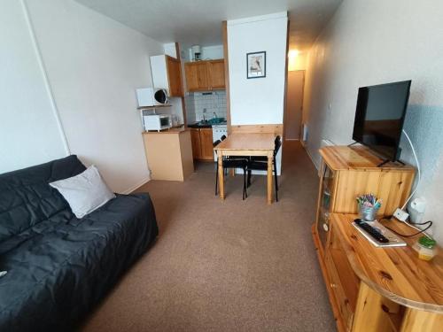 un salon avec un canapé et une table avec une télévision dans l'établissement Studio confortable à La Pierre St Martin, proche des pistes, avec loggia et ascenseur. - FR-1-602-64, à Arette