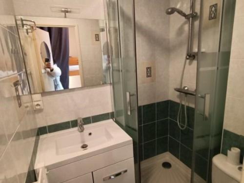 une personne prenant une photo d'une salle de bains avec douche dans l'établissement Appartement cosy 6 pers, proche pistes, balcon, casier à skis, parking gratuit - FR-1-602-25, à Arette