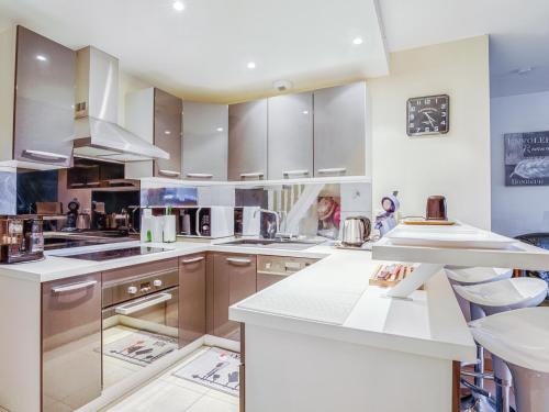 une grande cuisine avec comptoirs blancs et appareils en acier inoxydable dans l'établissement Maison T5 à Biscarrosse avec 4 chambres, clim, WIFI, terrasse, proche activités et plages - FR-1-521-156, à Biscarrosse