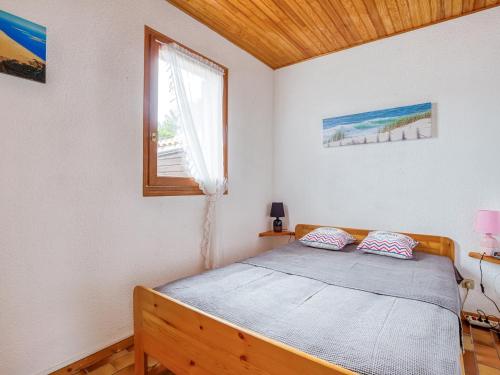 une chambre avec un lit et une fenêtre dans l'établissement Maison T3 mezzanine, 6 pers, WiFi, près de l’océan, quartier résidentiel, Biscarrosse - FR-1-521-157, à Biscarrosse