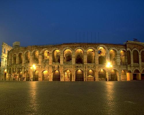 a large building with lights in front of it at night at Opera Relais De Charme - Aparthotel in Verona